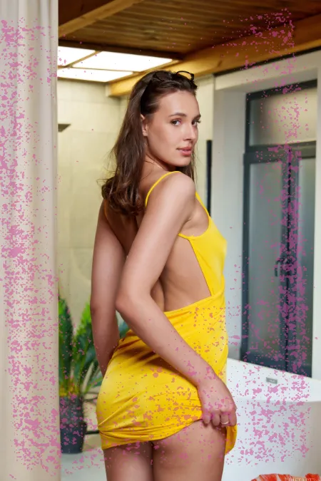 Lydie brunette glamour en robe jaune et lunettes au téléphone rose
